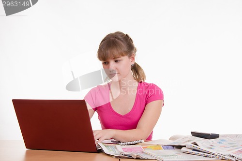 Image of Girl working behind the notebook