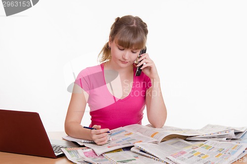 Image of Young woman calling on a newspaper ad