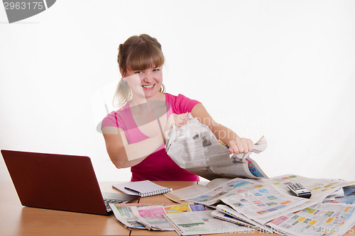 Image of The girl at the table with pleasure tearing paper