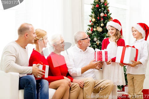 Image of smiling family with gifts at home