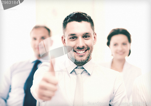 Image of businessman in office showign thumbs up