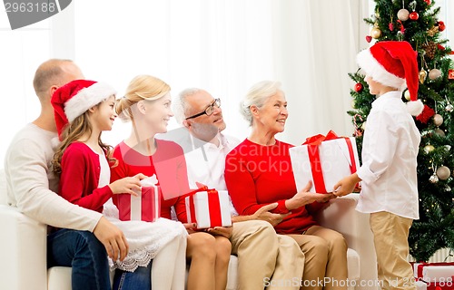 Image of smiling family with gifts at home