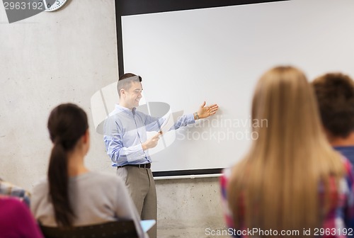 Image of group of students and smiling teacher with notepad