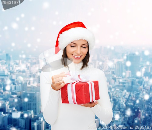 Image of smiling woman in santa helper hat with gift box