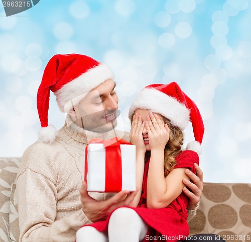 Image of smiling daughter waiting for present from father