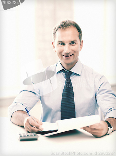 Image of businessman with notebook and calculator