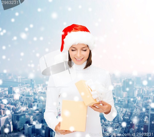 Image of smiling woman in santa helper hat with gift box