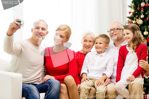 Image of smiling family with camera at home