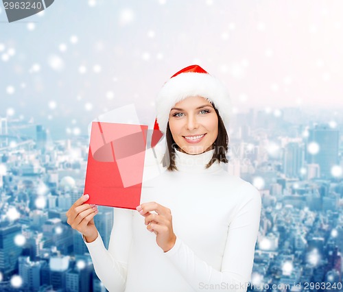 Image of smiling woman in santa hat with greeting card