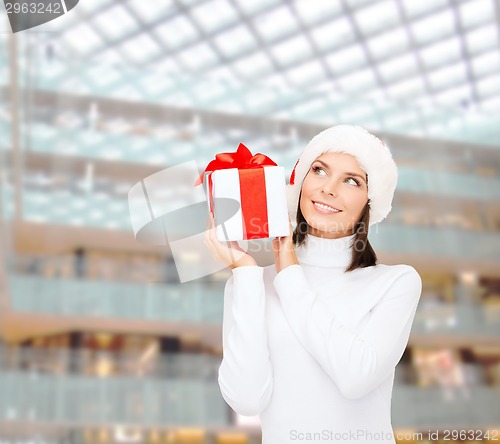 Image of smiling woman in santa helper hat with gift box