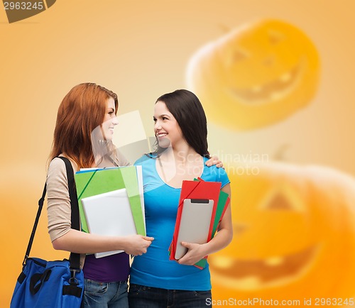 Image of smiling student girl with books and bag