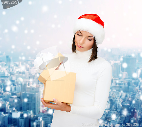 Image of woman in santa helper hat with gift box