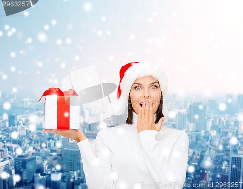 Image of smiling woman in santa helper hat with gift box