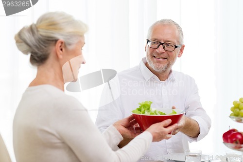 Image of smiling senior couple having dinner at home