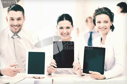 Image of business team showing tablet pcs in office