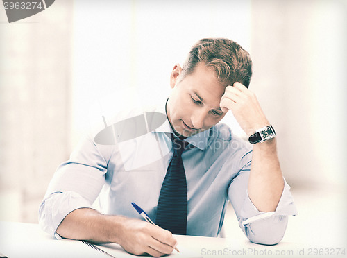 Image of businessman writing in notebook