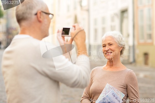 Image of senior couple photographing on city street