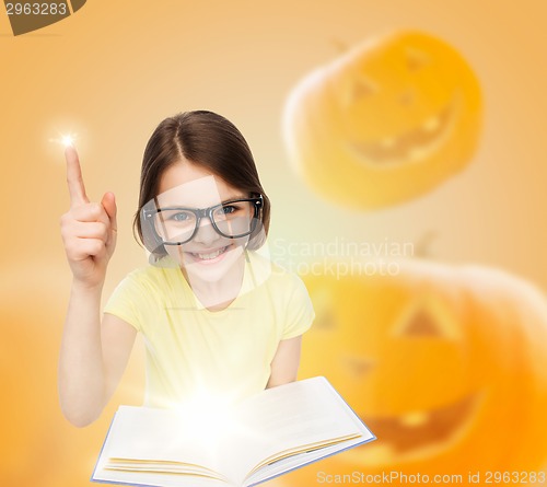Image of smiling girl in glasses over pumpkins background