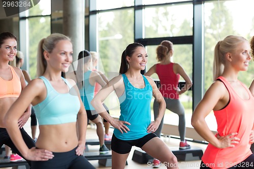 Image of group of women working out with steppers in gym