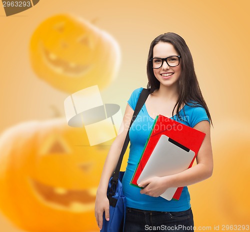 Image of smiling student girl with books and bag