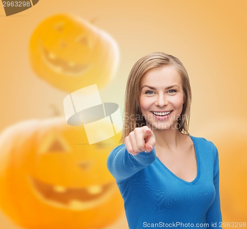 Image of smiling young woman pointing finger at you
