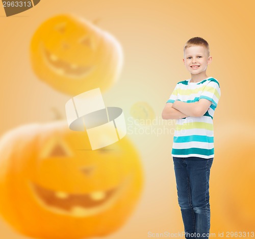 Image of smiling boy over pumpkins background