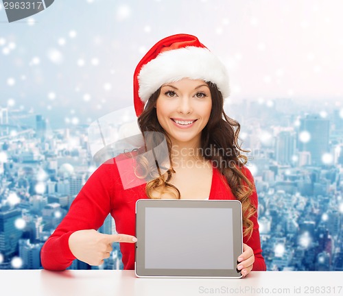 Image of smiling woman in santa hat with gift and tablet pc