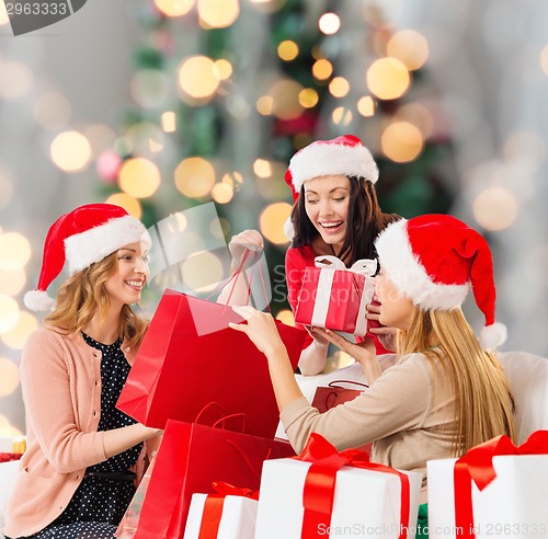 Image of smiling young women in santa hats with gifts