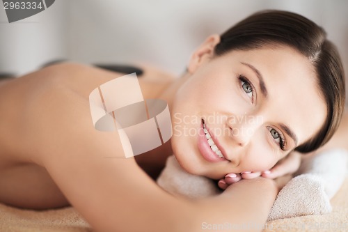 Image of beautiful woman in spa salon with hot stones