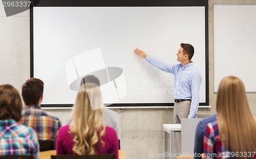 Image of group of students and smiling teacher in classroom