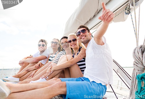 Image of smiling friends sitting on yacht deck