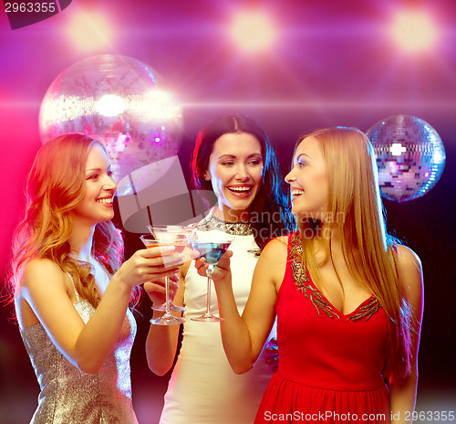 Image of three smiling women with cocktails and disco ball