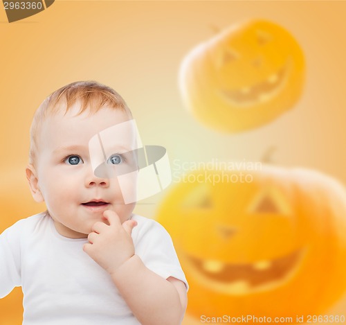 Image of smiling baby over pumpkins background