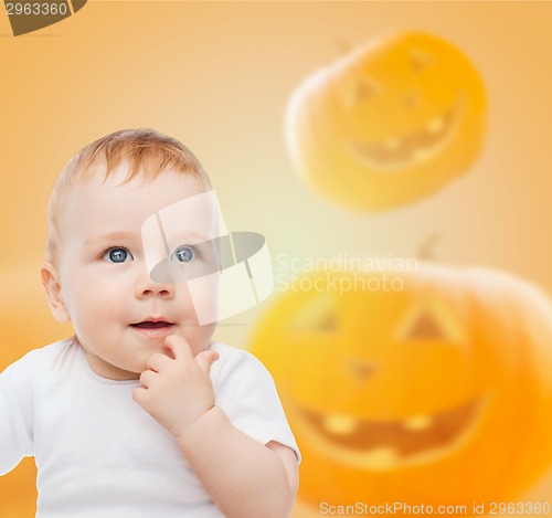 Image of smiling baby over pumpkins background