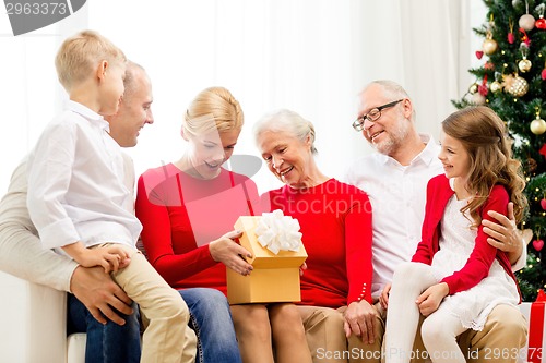 Image of smiling family with gifts at home