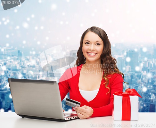 Image of smiling woman with credit card and laptop