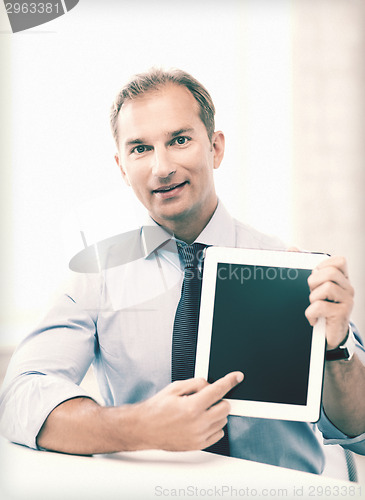 Image of smiling businessman with tablet pc in office