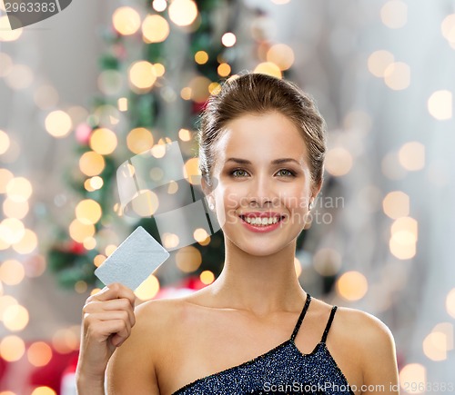 Image of smiling woman in evening dress holding credit card