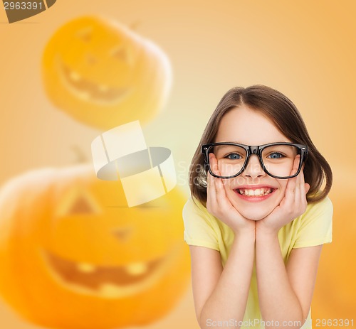 Image of smiling girl in glasses over pumpkins background