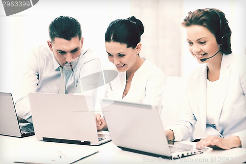 Image of group of people working with laptops in office