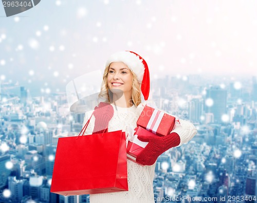 Image of smiling young woman in santa helper hat with gifts