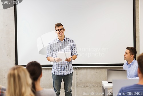 Image of group of smiling students and teacher in classroom