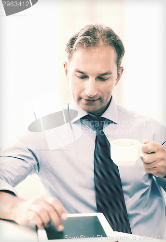 Image of businessman with tablet pc and coffee in office