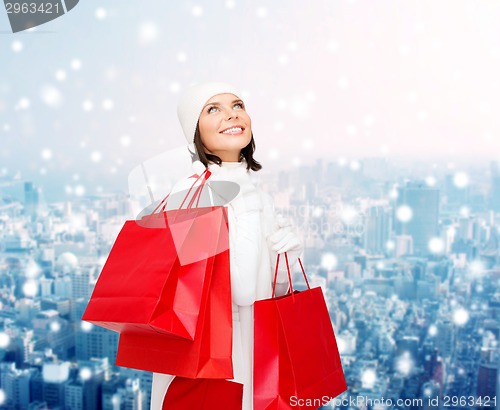 Image of smiling young woman with red shopping bags