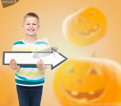 Image of smiling little boy holding big white arrow