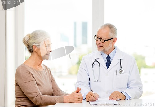 Image of smiling senior woman and doctor meeting