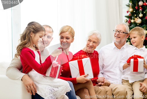 Image of smiling family with gifts at home