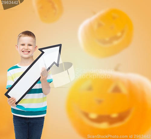 Image of smiling little boy holding big white arrow