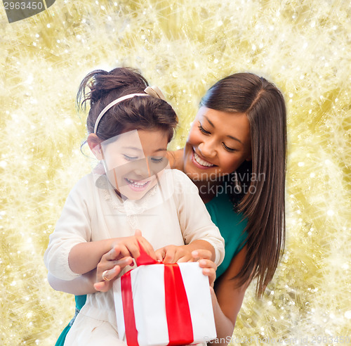 Image of happy mother and little girl with gift box