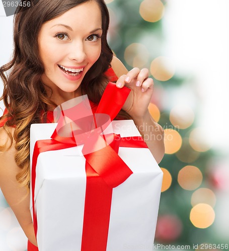 Image of smiling woman in red dress with gift box